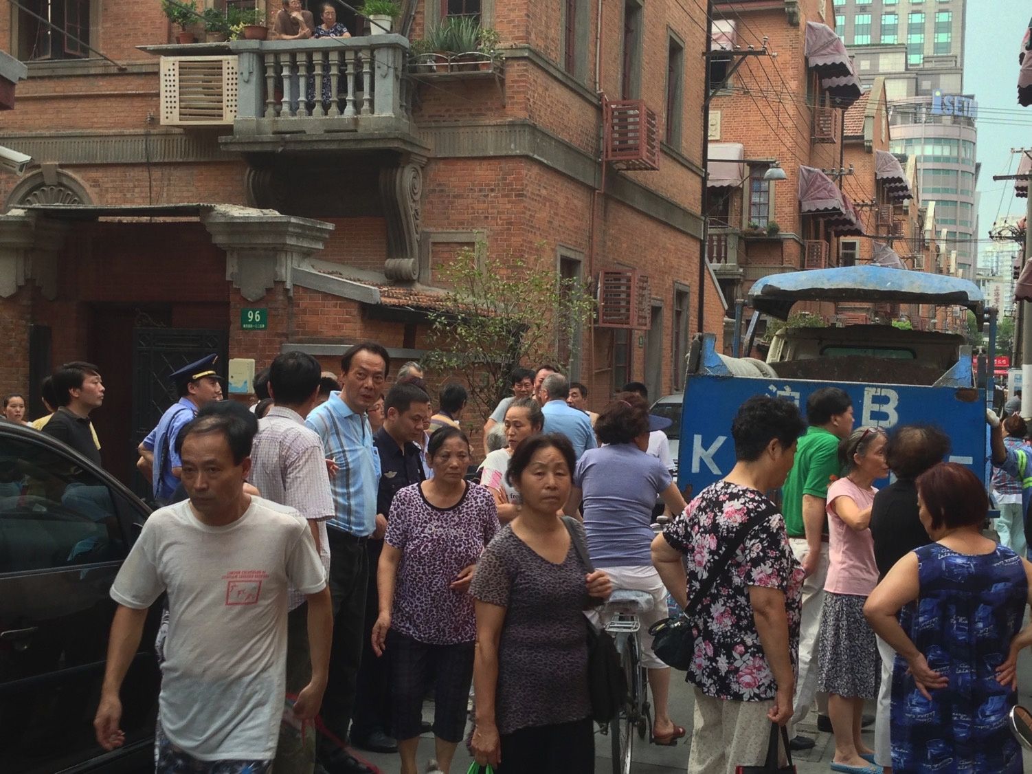 Residents and shopkeepers in the street during an enforcement action.